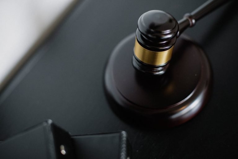 Close-up of a wooden judges gavel on a black desk, symbolizing justice and law.